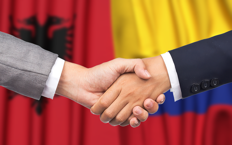 Handshake in front of Colombian and Albanian flags