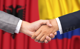 Handshake in front of Colombian and Albanian flags