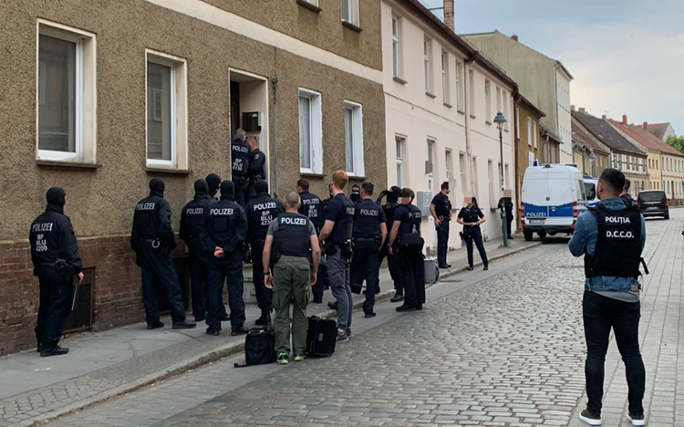 Germany police officers at street in front of house